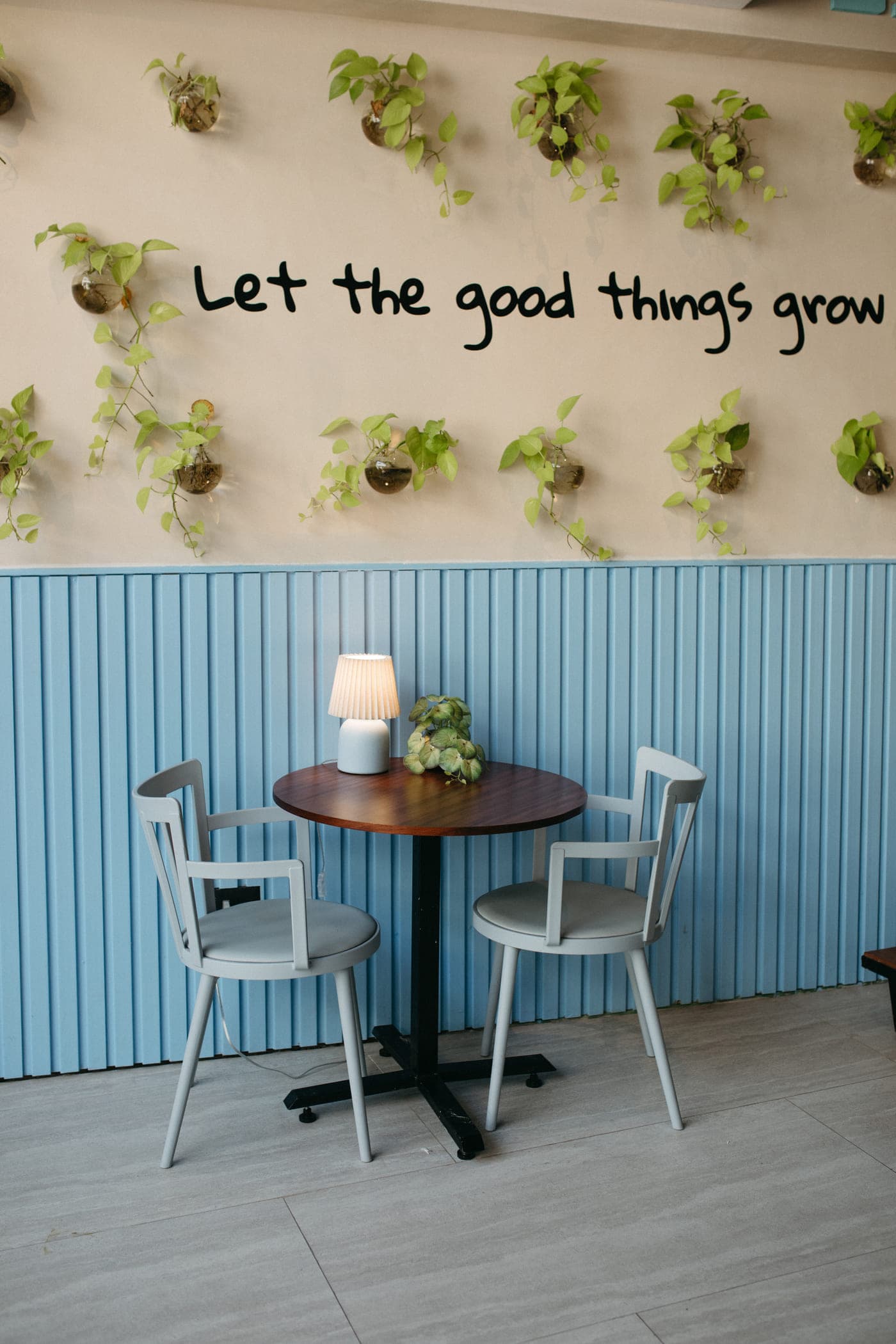 Rincón del taller con muro de plantas y el lema «Let the good things grow»